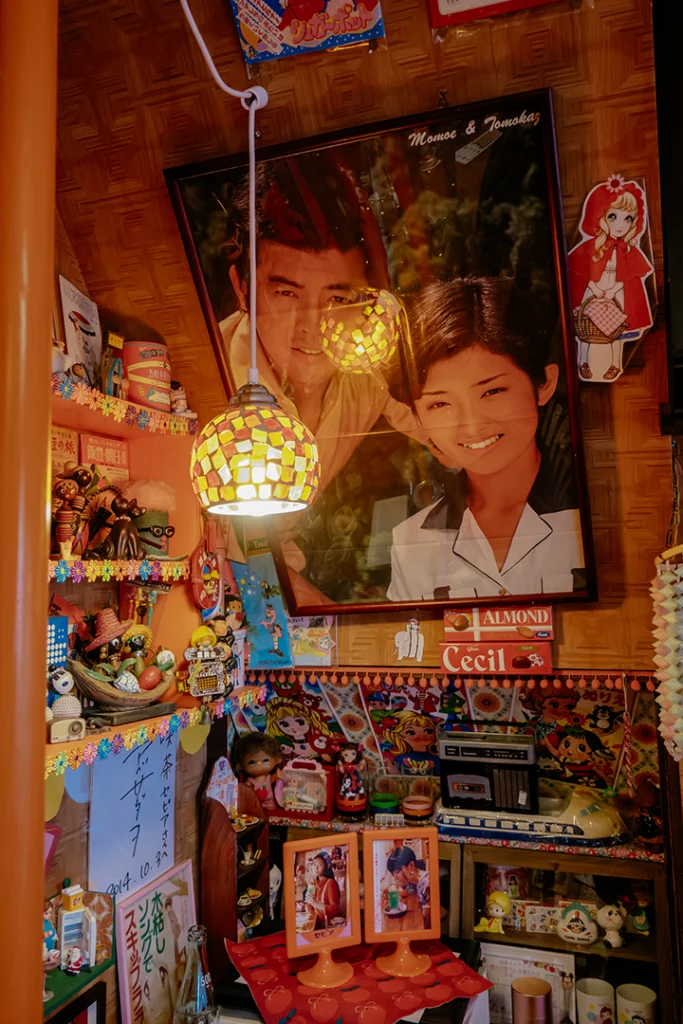Dettaglio dell'arredamento del Cafè Sepia a Shibamata: un poster vintage dell'era Shōwa e una lampada decorativa in un tipico kissaten nostalgico di Tokyo.