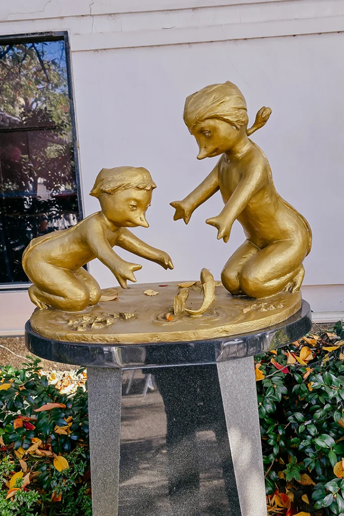 Statua dorata di due Kappa che giocano con un pesce a Fushimi, Kyoto.